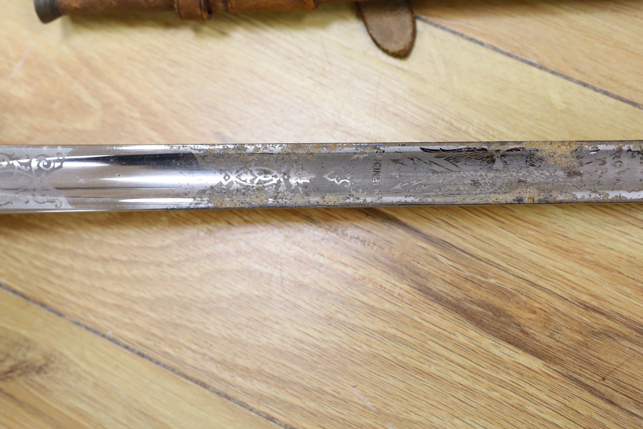 A George V military dress sword in brown leather covered scabbard, 102cm long, and a Middle Eastern dagger with carved and painted handle